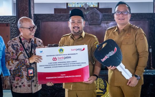 Apresiasi CSR Bank Jatim, Bupati Yani Serahkan 3 Mobil Operasional untuk Ponpes dan GP Ansor Bawean Gresik ,siliwangipost1.com – Pemerintah Kabupaten (Pemkab) Gresik menerima tiga unit mobil operasional dari Bank Jatim melalui program Corporate Social Responsibility (CSR). Kendaraan tersebut diserahkan kepada Pondok Pesantren Sirojul Haromain, Pondok Pesantren Ar-Roudloh, dan GP Ansor Bawean. Serah terima ditandai dengan penandatanganan berita acara oleh Wakil Direktur Utama Bank Jatim, Arief Wicaksono, bersama Bupati Gresik Fandi Akhmad Yani yang didampingi Wakil Bupati Asluchul Alif di Pendopo Kabupaten Gresik, Selasa (3/3/2026). Bupati Yani menyampaikan apresiasi atas bantuan kendaraan operasional tersebut. Ia berharap fasilitas itu dapat mendukung kelancaran kegiatan keagamaan, sosial, dan pendidikan di lingkungan pondok pesantren, serta memperlancar mobilitas GP Ansor di wilayah kepulauan Bawean. “Kendaraan ini akan menjadi bagian operasional pondok pesantren yang masih berkembang dan perlu dukungan pemerintah daerah. Untuk GP Ansor, selain menunjang aktivitas organisasi, semoga juga bisa dimanfaatkan membantu masyarakat,” ujarnya. Menurut Bupati Yani, sebagai salah satu bank pembangunan daerah terbesar di Kabupaten Gresik, Bank Jatim memiliki peran strategis dalam mendorong pertumbuhan ekonomi daerah, memperkuat sektor UMKM, serta mendukung pembiayaan pembangunan. Kontribusi tersebut, lanjutnya, tidak hanya melalui layanan perbankan, tetapi juga melalui program CSR yang konsisten memberi manfaat langsung kepada masyarakat. Ia menambahkan, Pemkab Gresik terus mendorong agar program CSR selaras dengan prioritas pembangunan daerah, meliputi pendidikan, kesehatan, infrastruktur, lingkungan hidup, pemberdayaan ekonomi masyarakat, sosial-keagamaan, hingga olahraga dan seni budaya. “Sinergi seperti inilah yang menjadi kekuatan utama dalam mempercepat pencapaian target pembangunan daerah,” tegasnya. Bupati Yani berharap bantuan tersebut dapat dikelola secara optimal dan memberikan dampak jangka panjang bagi masyarakat. Ia optimistis kedua pondok pesantren yang sedang berkembang itu mampu mencetak generasi unggul secara spiritual dan intelektual. Sementara itu, Wakil Direktur Utama Bank Jatim, Arief Wicaksono, menyampaikan bahwa bantuan tersebut merupakan bagian dari komitmen Bank Jatim dalam mendukung pembangunan daerah. “Kami berkomitmen mendukung program-program pemerintah daerah guna mewujudkan kesejahteraan dan membangun perekonomian yang lebih kuat. Semoga bantuan kendaraan operasional ini memberikan manfaat nyata bagi masyarakat,” singkatnya. Turut hadir dalam kegiatan tersebut Kepala Bappeda Gresik Edi Hadisiswoyo, Asisten Pemerintahan dan Kesejahteraan Rakyat Suprapto, Pimpinan Bank Jatim Cabang Gresik Abdullah Basid, serta perwakilan pengurus pondok pesantren dan Ketua GP Ansor Bawean. SL/Redaksi