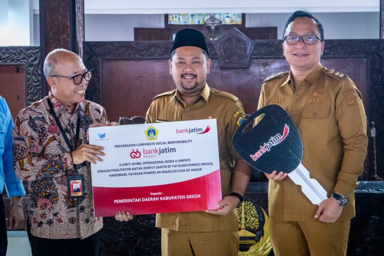 Apresiasi CSR Bank Jatim, Bupati Yani Serahkan 3 Mobil Operasional untuk Ponpes dan GP Ansor Bawean Gresik ,siliwangipost1.com – Pemerintah Kabupaten (Pemkab) Gresik menerima tiga unit mobil operasional dari Bank Jatim melalui program Corporate Social Responsibility (CSR). Kendaraan tersebut diserahkan kepada Pondok Pesantren Sirojul Haromain, Pondok Pesantren Ar-Roudloh, dan GP Ansor Bawean. Serah terima ditandai dengan penandatanganan berita acara oleh Wakil Direktur Utama Bank Jatim, Arief Wicaksono, bersama Bupati Gresik Fandi Akhmad Yani yang didampingi Wakil Bupati Asluchul Alif di Pendopo Kabupaten Gresik, Selasa (3/3/2026). Bupati Yani menyampaikan apresiasi atas bantuan kendaraan operasional tersebut. Ia berharap fasilitas itu dapat mendukung kelancaran kegiatan keagamaan, sosial, dan pendidikan di lingkungan pondok pesantren, serta memperlancar mobilitas GP Ansor di wilayah kepulauan Bawean. “Kendaraan ini akan menjadi bagian operasional pondok pesantren yang masih berkembang dan perlu dukungan pemerintah daerah. Untuk GP Ansor, selain menunjang aktivitas organisasi, semoga juga bisa dimanfaatkan membantu masyarakat,” ujarnya. Menurut Bupati Yani, sebagai salah satu bank pembangunan daerah terbesar di Kabupaten Gresik, Bank Jatim memiliki peran strategis dalam mendorong pertumbuhan ekonomi daerah, memperkuat sektor UMKM, serta mendukung pembiayaan pembangunan. Kontribusi tersebut, lanjutnya, tidak hanya melalui layanan perbankan, tetapi juga melalui program CSR yang konsisten memberi manfaat langsung kepada masyarakat. Ia menambahkan, Pemkab Gresik terus mendorong agar program CSR selaras dengan prioritas pembangunan daerah, meliputi pendidikan, kesehatan, infrastruktur, lingkungan hidup, pemberdayaan ekonomi masyarakat, sosial-keagamaan, hingga olahraga dan seni budaya. “Sinergi seperti inilah yang menjadi kekuatan utama dalam mempercepat pencapaian target pembangunan daerah,” tegasnya. Bupati Yani berharap bantuan tersebut dapat dikelola secara optimal dan memberikan dampak jangka panjang bagi masyarakat. Ia optimistis kedua pondok pesantren yang sedang berkembang itu mampu mencetak generasi unggul secara spiritual dan intelektual. Sementara itu, Wakil Direktur Utama Bank Jatim, Arief Wicaksono, menyampaikan bahwa bantuan tersebut merupakan bagian dari komitmen Bank Jatim dalam mendukung pembangunan daerah. “Kami berkomitmen mendukung program-program pemerintah daerah guna mewujudkan kesejahteraan dan membangun perekonomian yang lebih kuat. Semoga bantuan kendaraan operasional ini memberikan manfaat nyata bagi masyarakat,” singkatnya. Turut hadir dalam kegiatan tersebut Kepala Bappeda Gresik Edi Hadisiswoyo, Asisten Pemerintahan dan Kesejahteraan Rakyat Suprapto, Pimpinan Bank Jatim Cabang Gresik Abdullah Basid, serta perwakilan pengurus pondok pesantren dan Ketua GP Ansor Bawean. SL/Redaksi